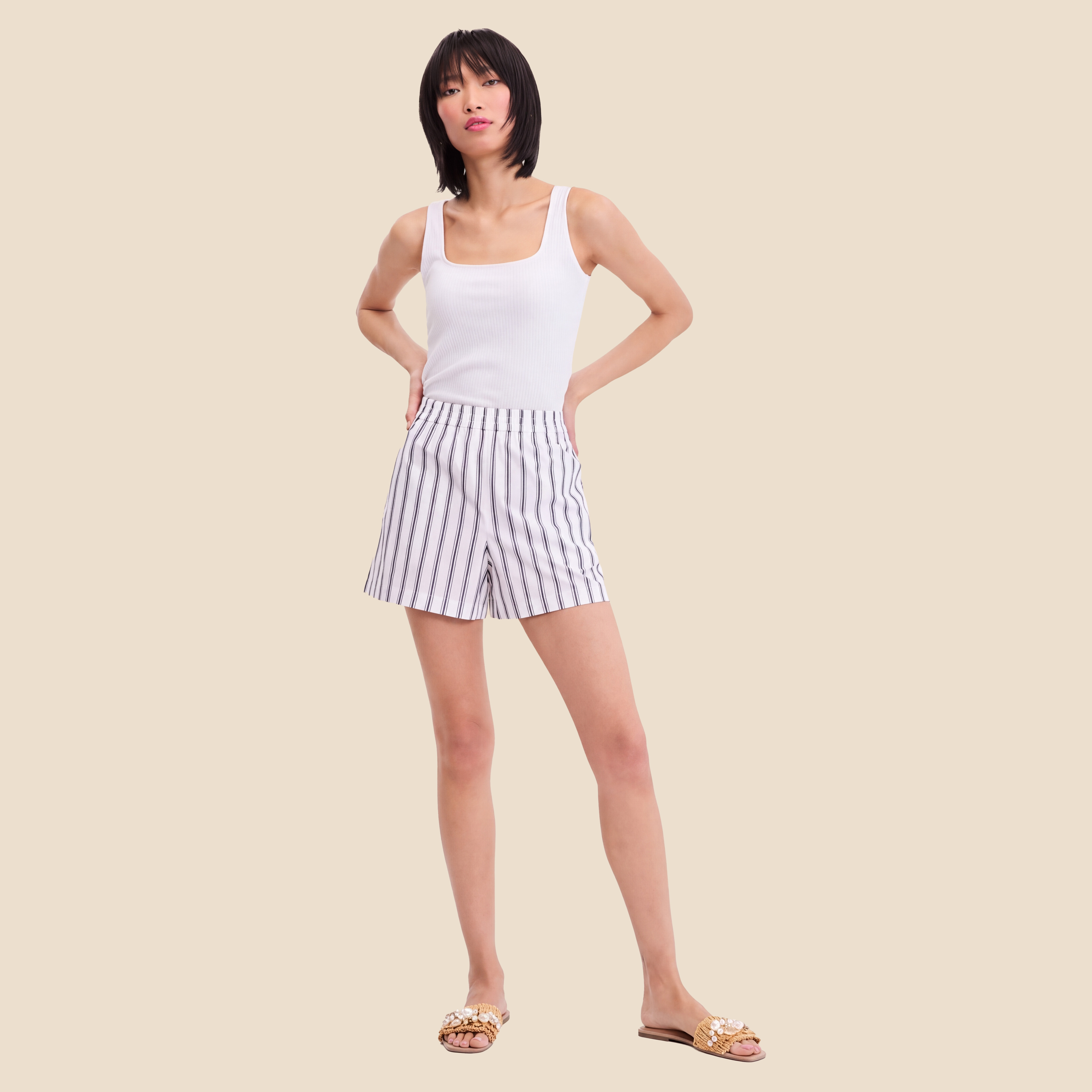 Woman in Memorial Day white tank and striped shorts 