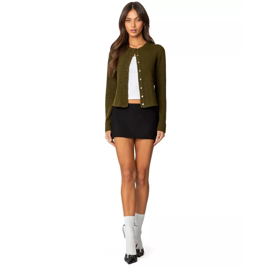 Woman in green cardigan and white tank top