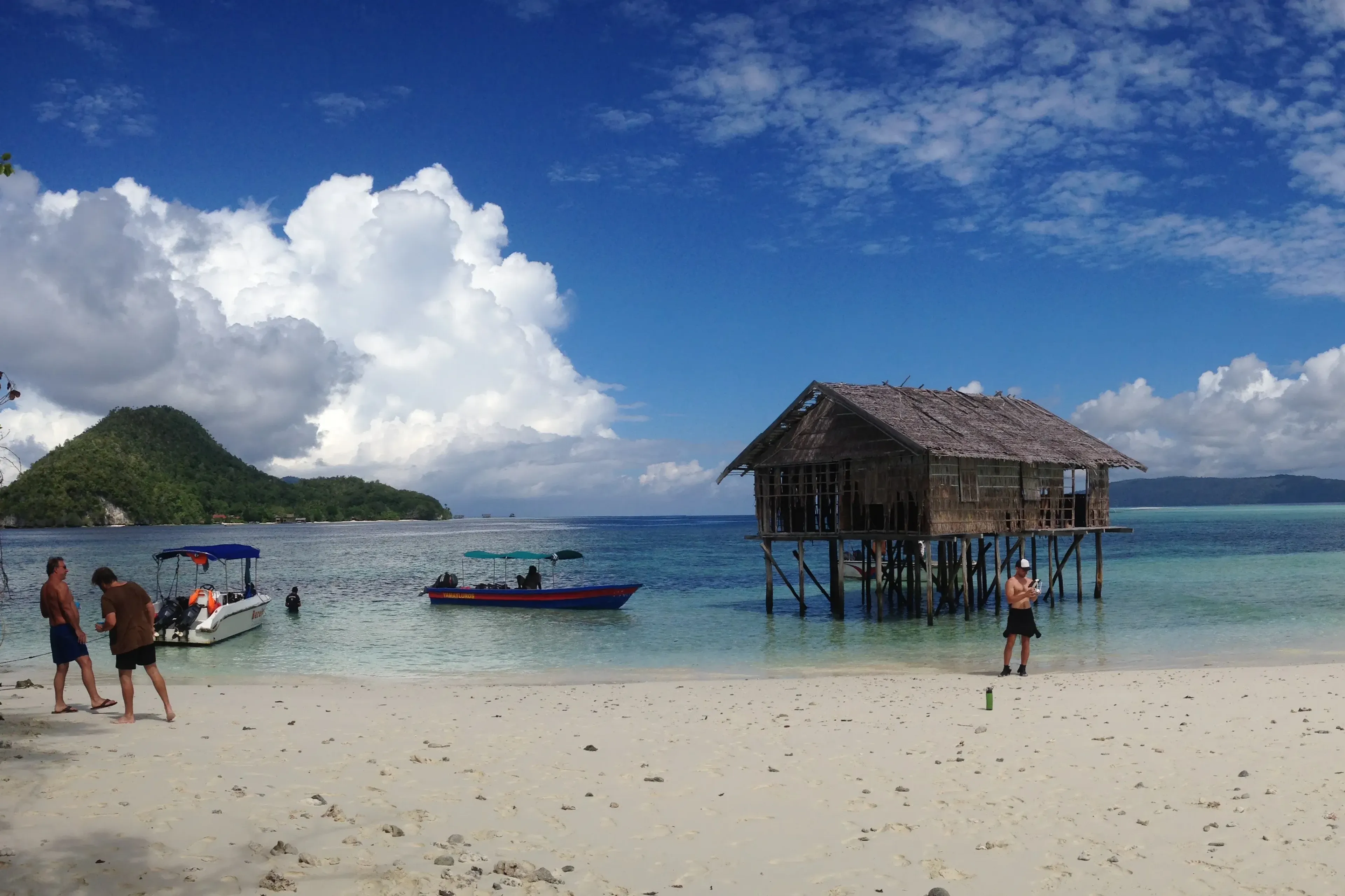 divers on an island in raja ampat indonesia