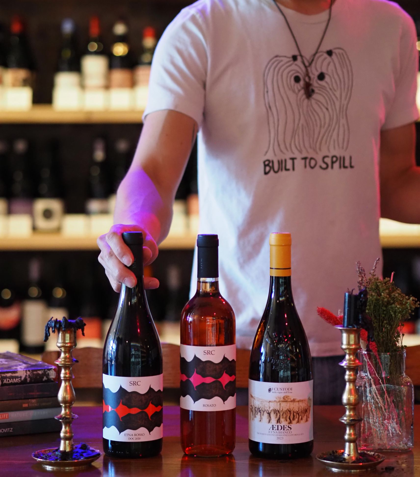 Owner of Bebop showing off bottles for the wine club