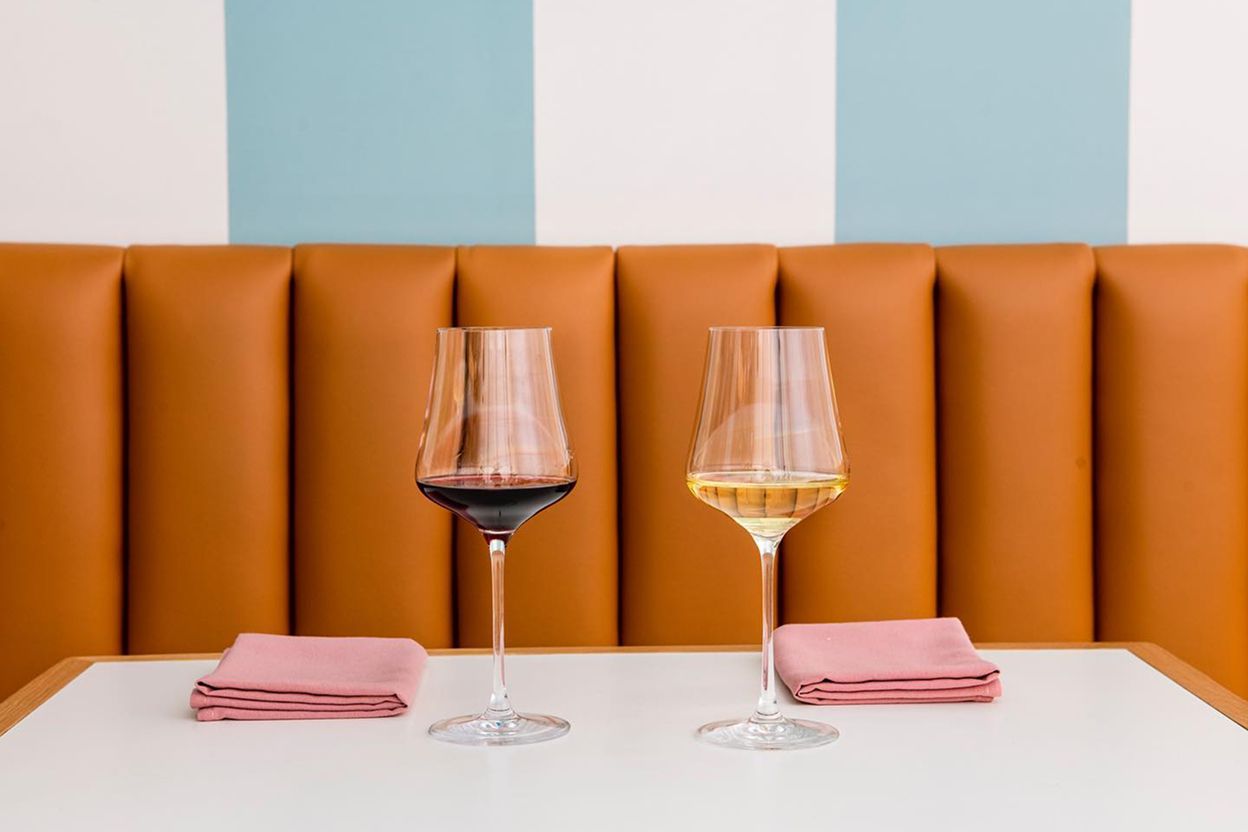 Two glasses of wine, one red and one white, on a table at Hilda and Jesse