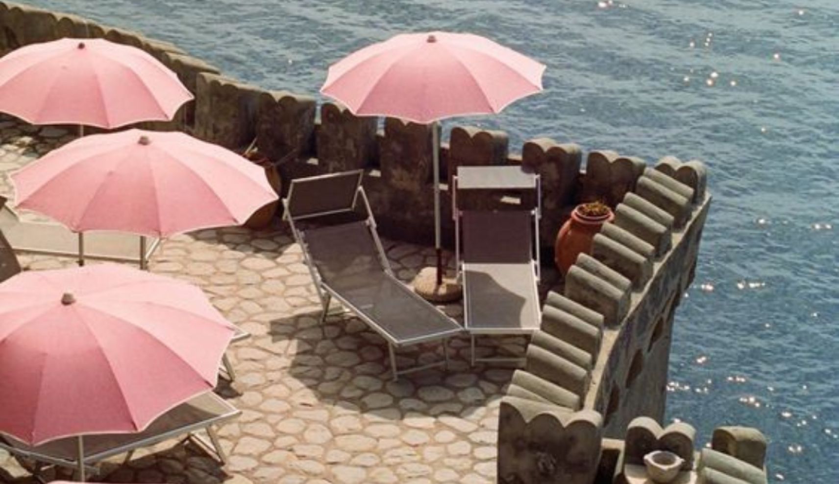 Photo of pink beach umbrella on a pier