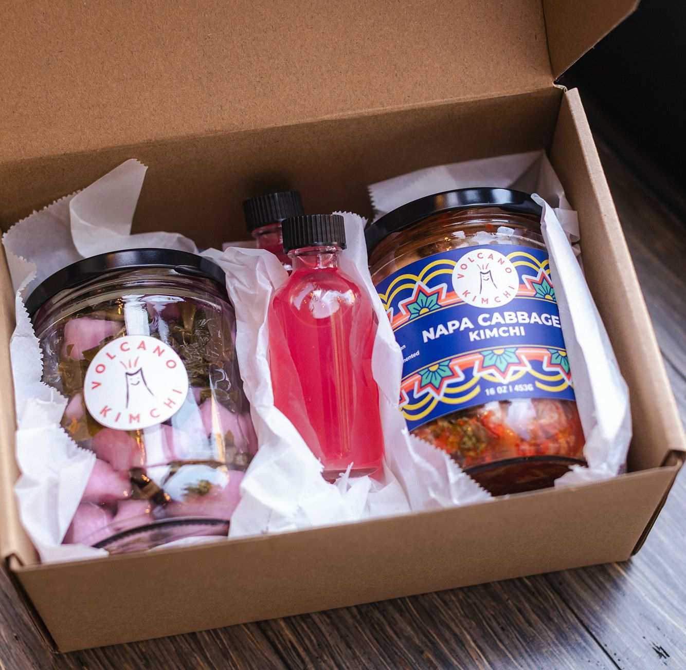Example of a monthly Kimchi CLub box featuring a signature jar, a surprise ferment of the month jar, and a wild fermented drink from Volcano Kimchi.