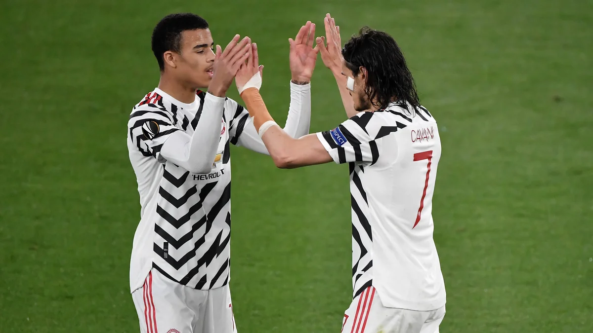 Edinson Cavani and Mason Greenwood celebrating a goal during a football match.