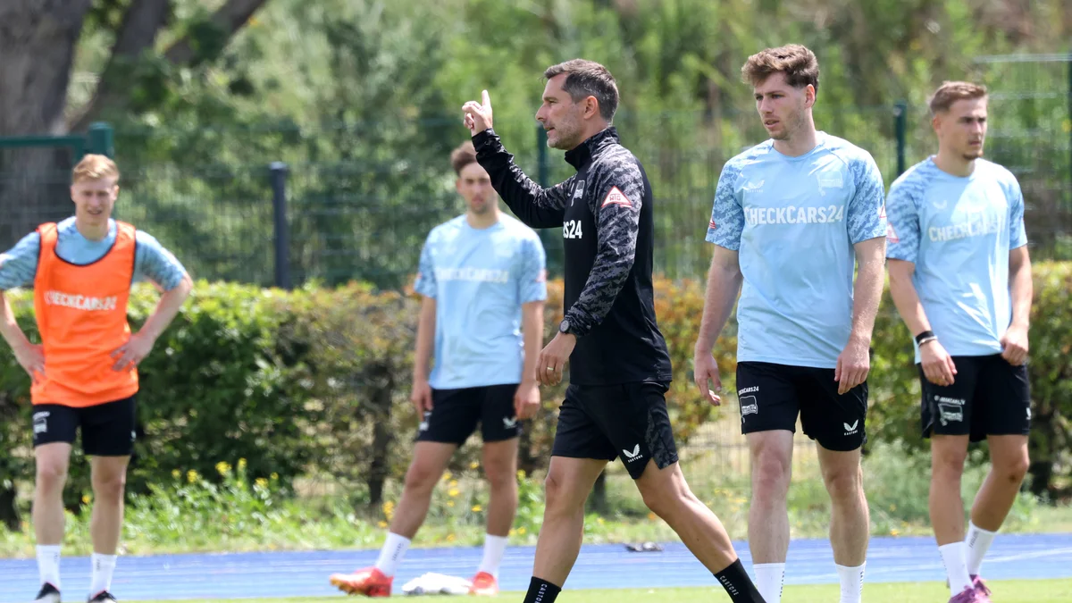 Hertha BSC coach Stefan Leitl talks with players Leon Jensen and Gustav Christensen during training in Berlin.