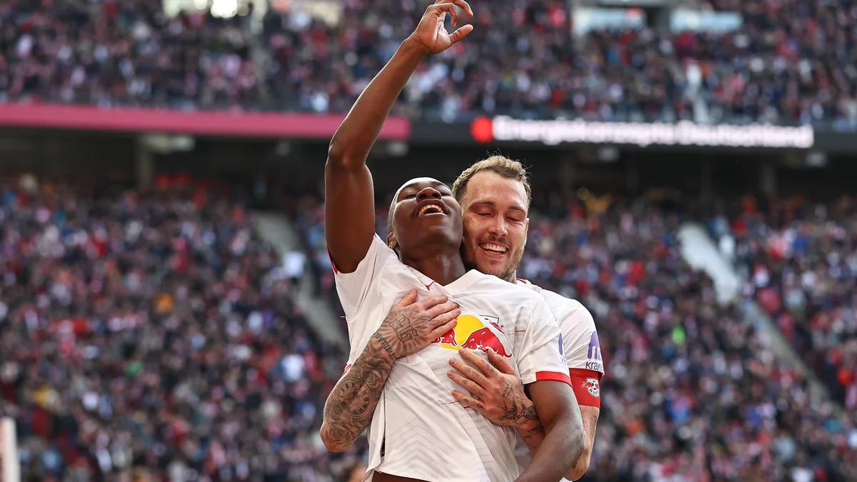 RB Leipzig players Yan Diomande and David Raum celebrate a goal during a Bundesliga match.