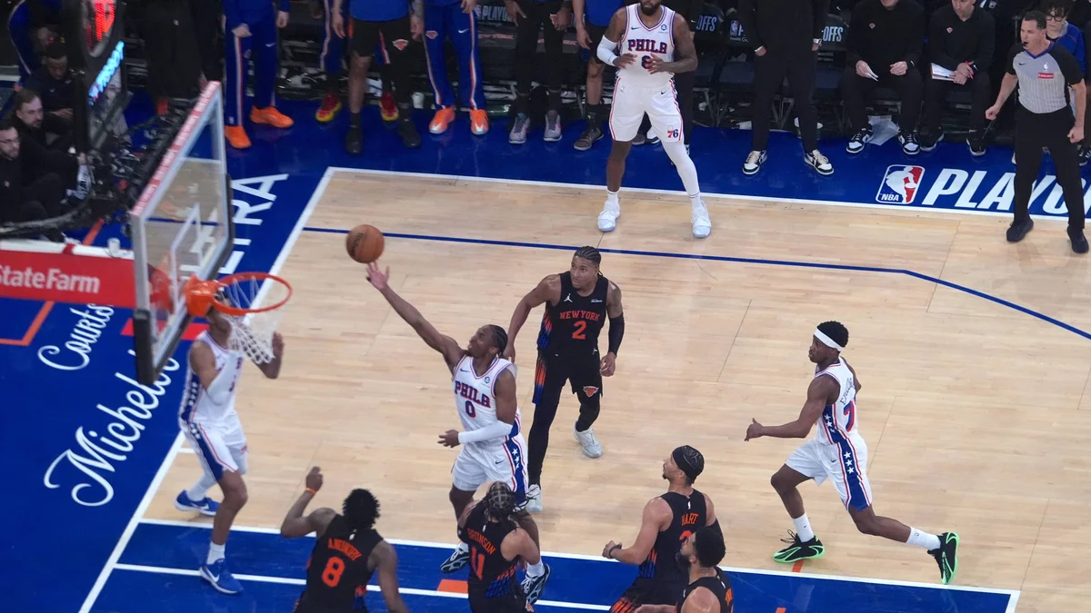 Tyrese Maxey of the 76ers shoots a basketball over a Knicks defender during an NBA playoff game.