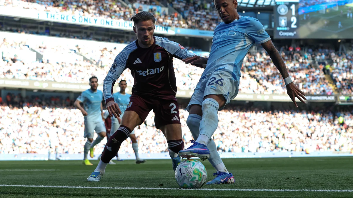 Savinho of Manchester City controls the ball under pressure from Matty Cash of Aston Villa during a Premier League match at Etihad Stadium.