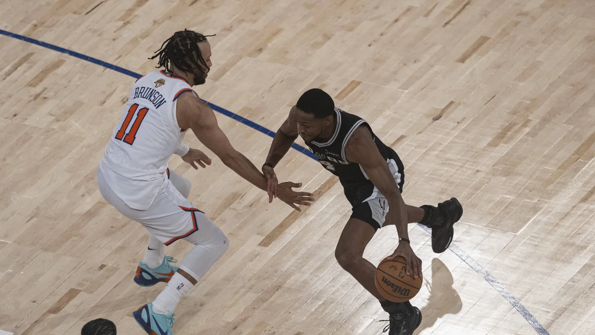 Jalen Brunson of the Knicks dribbles past De'Aaron Fox of the Spurs during an NBA Finals game.
