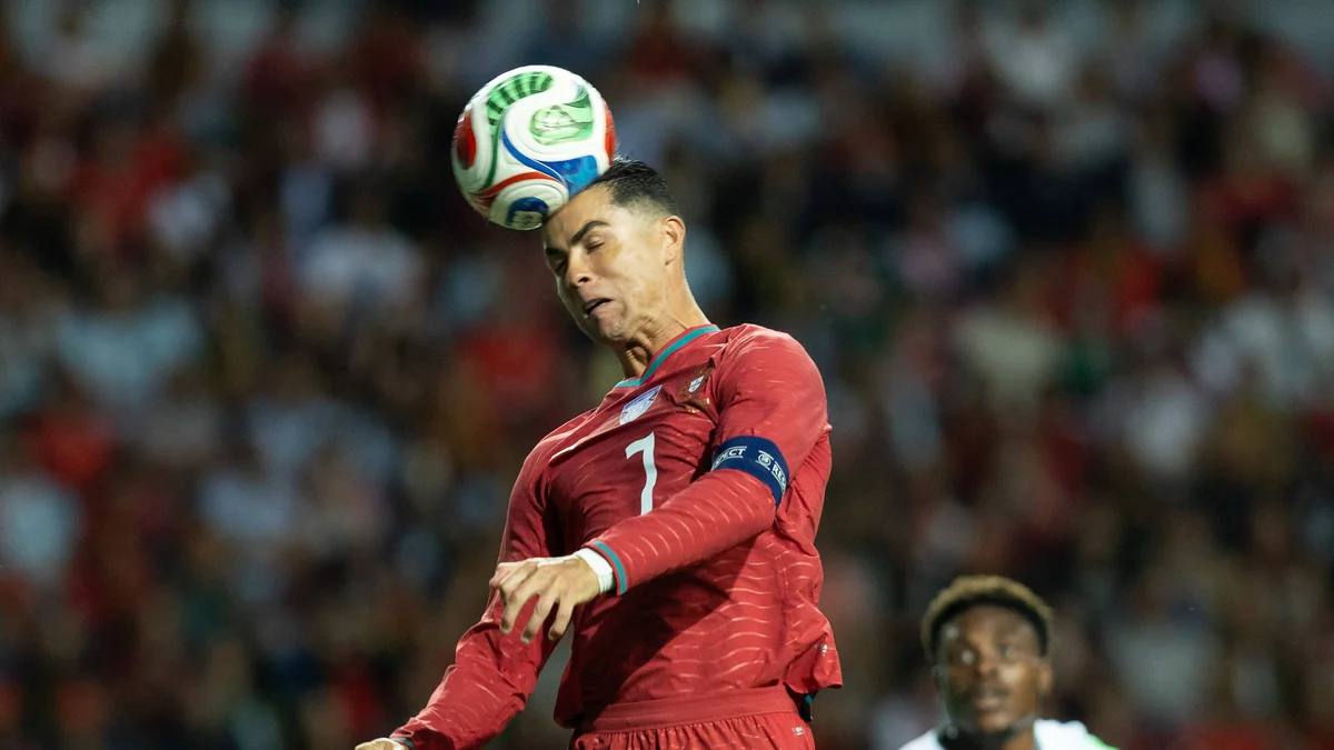Cristiano Ronaldo in his Portugal national team kit, number 7, dribbling the ball during a friendly match.