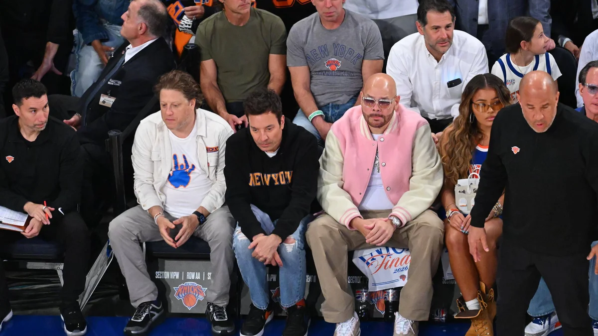Jimmy Fallon and Fat Joe celebrating at a New York Knicks NBA Finals game at Madison Square Garden.