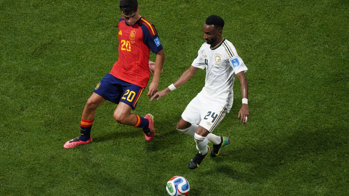 Spain's Pedri (left) dribbles past Saudi Arabia's Moteb Al Harbi during a 2026 FIFA World Cup match.