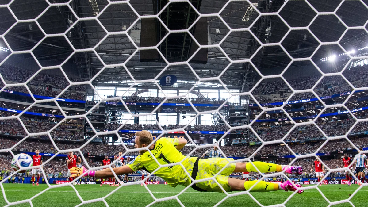 Austrian goalkeeper Alexander Schlager dives to save a penalty kick from Argentina's Lionel Messi during a World Cup match.