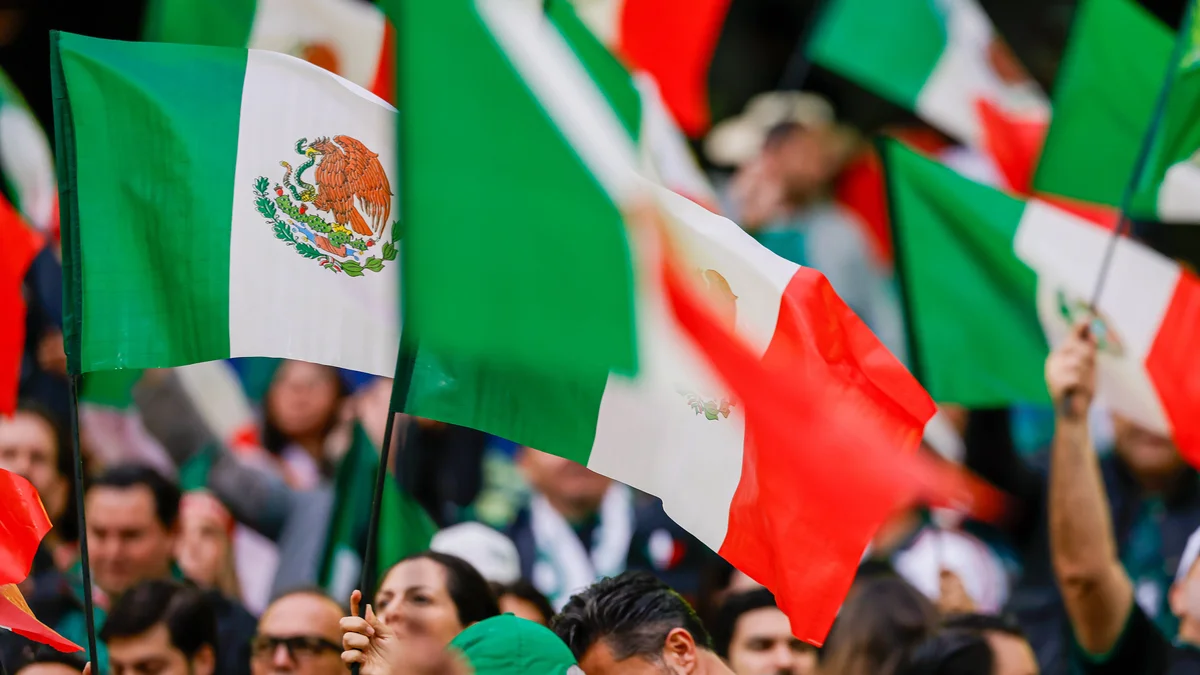 Energetic Mexico fans in a packed stadium cheer loudly during a 2026 FIFA World Cup match against England.