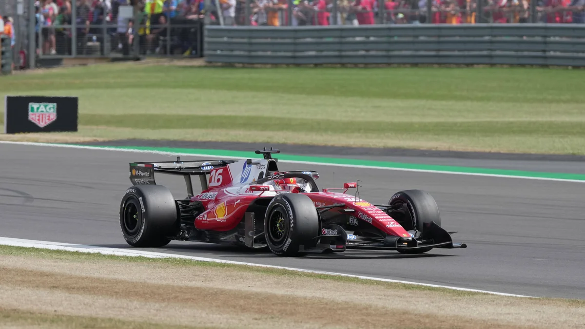 Charles Leclerc, wearing a red Ferrari racing suit and helmet, drives his red Ferrari Formula 1 car on the track.