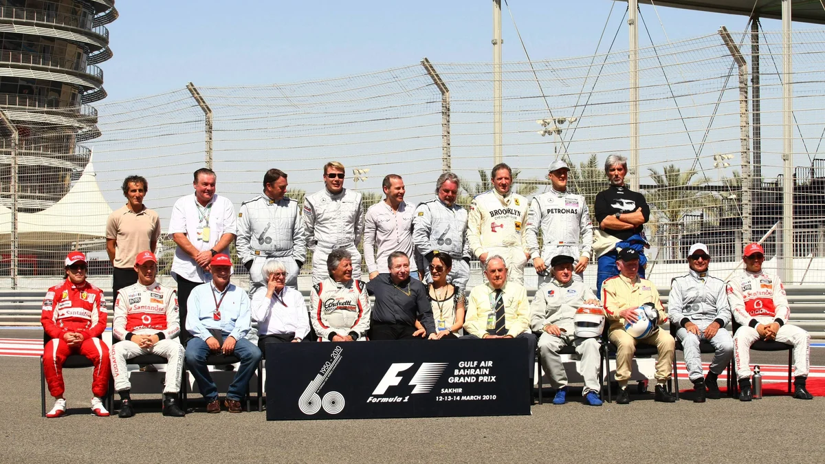 A large group of Formula 1 world champions, including Lewis Hamilton, Michael Schumacher, and Fernando Alonso, posing together.
