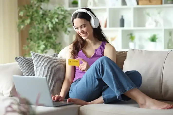 image of a woman with headphones happily purchasing online