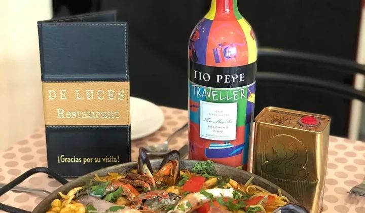 Mesa con paella y botella de vino