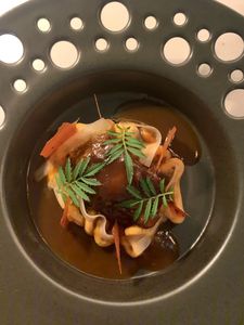 Plato principal de alta cocina con emplatado contemporáneo y salsas intensas.