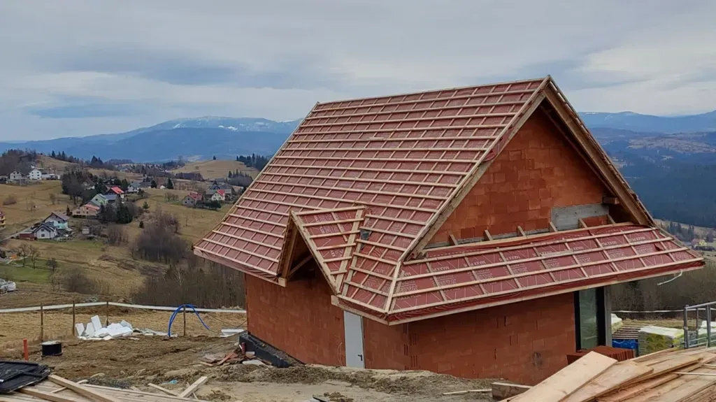 Izolacja termiczna na styku dachu i ściany zewnętrznej zakrywająca połączenie murłaty z wieńcem.