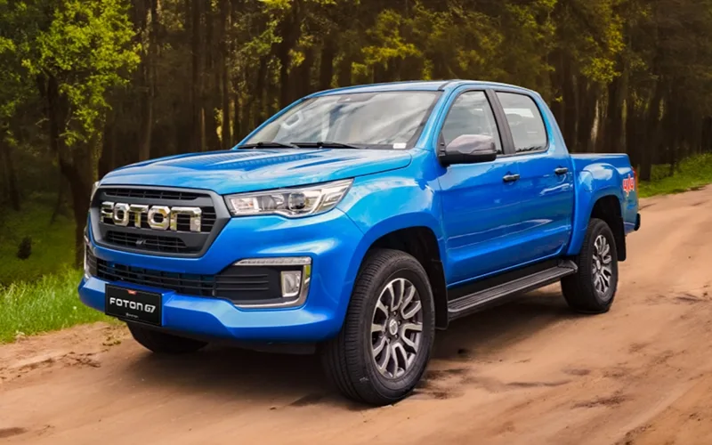 Foton G7 4x4 azul brillante, camioneta doble cabina en un sendero forestal.