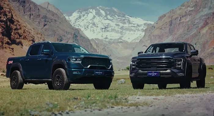 Dos camionetas Foton V7 4x4 en un paisaje de montaña con cumbres nevadas.