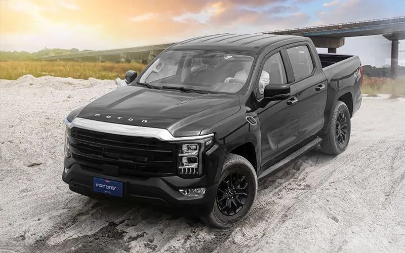 Foton V7 pickup negra doble cabina, potente modelo 4x4 en terreno arenoso.