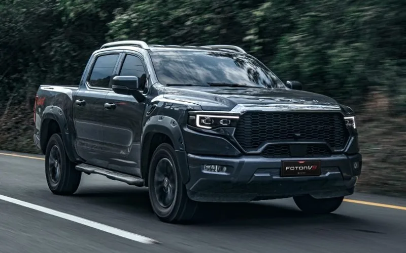 Imponente camioneta Foton V9 pickup negra doble cabina en movimiento por carretera, modelo hero para concesionario.