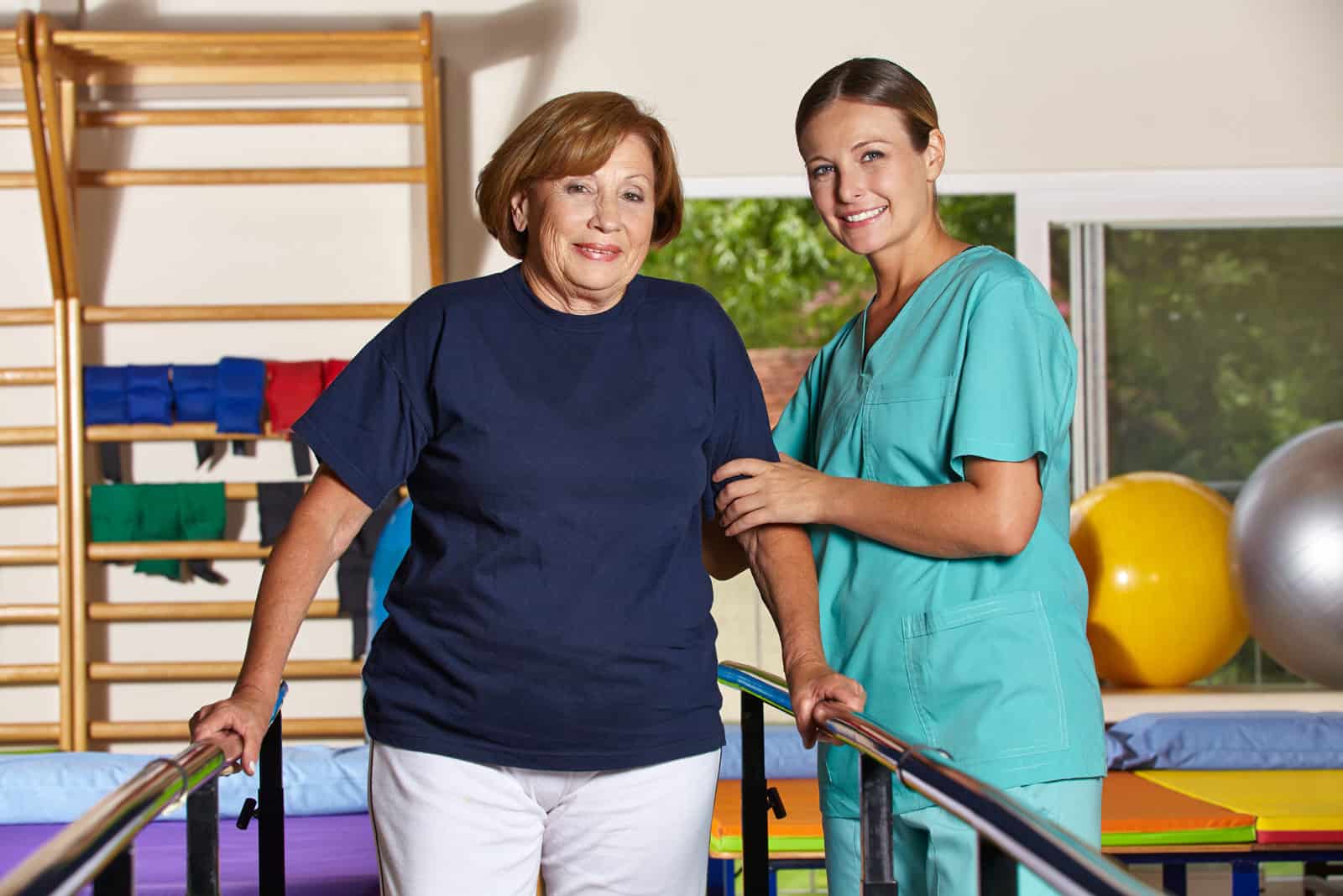 a nurse helps a senior woman with rehabilitation