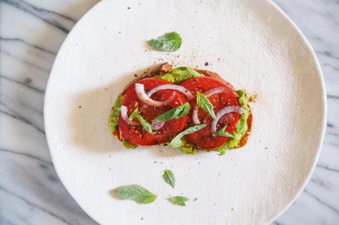 Pan tostado de aguacate, tomate y albahaca