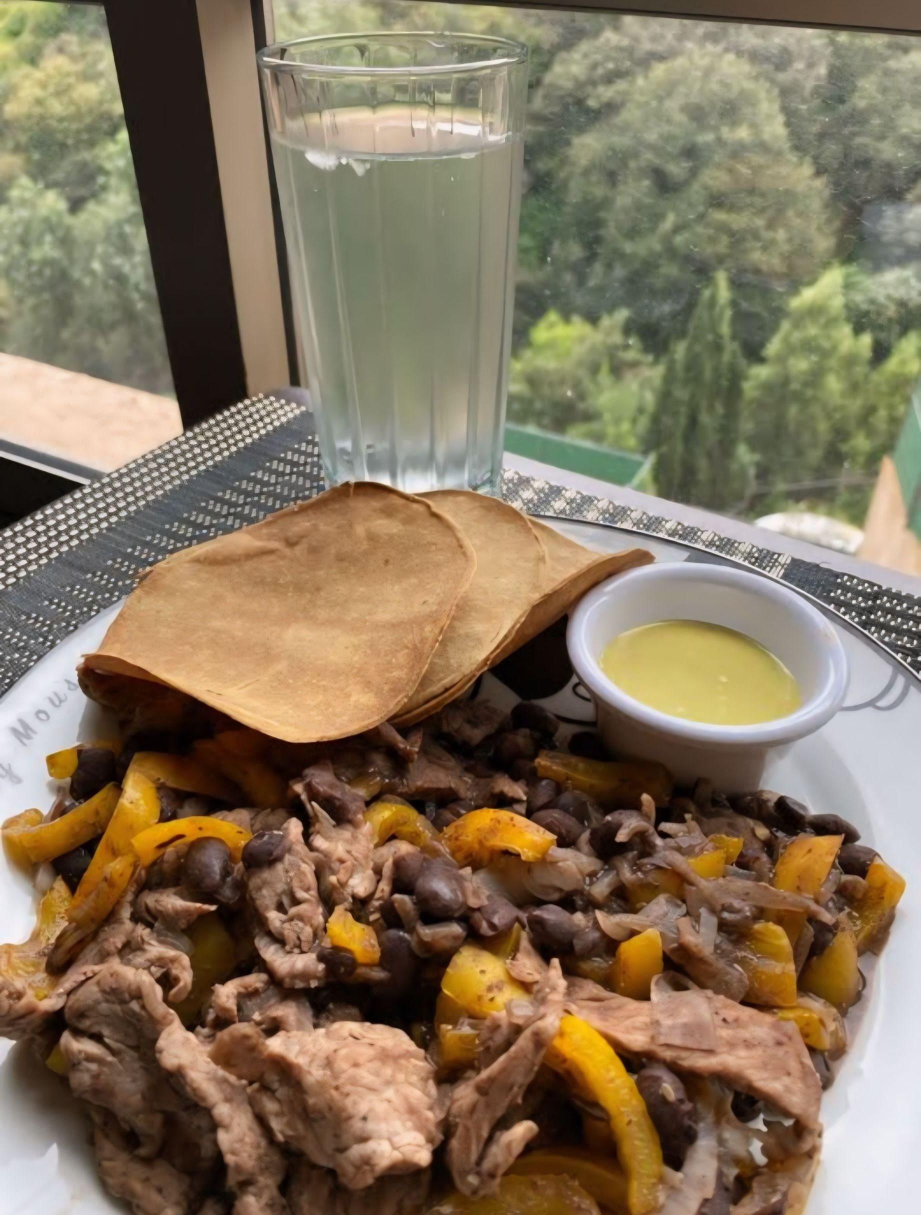 Pollo con pimientos y frijoles acompañado de doraditas