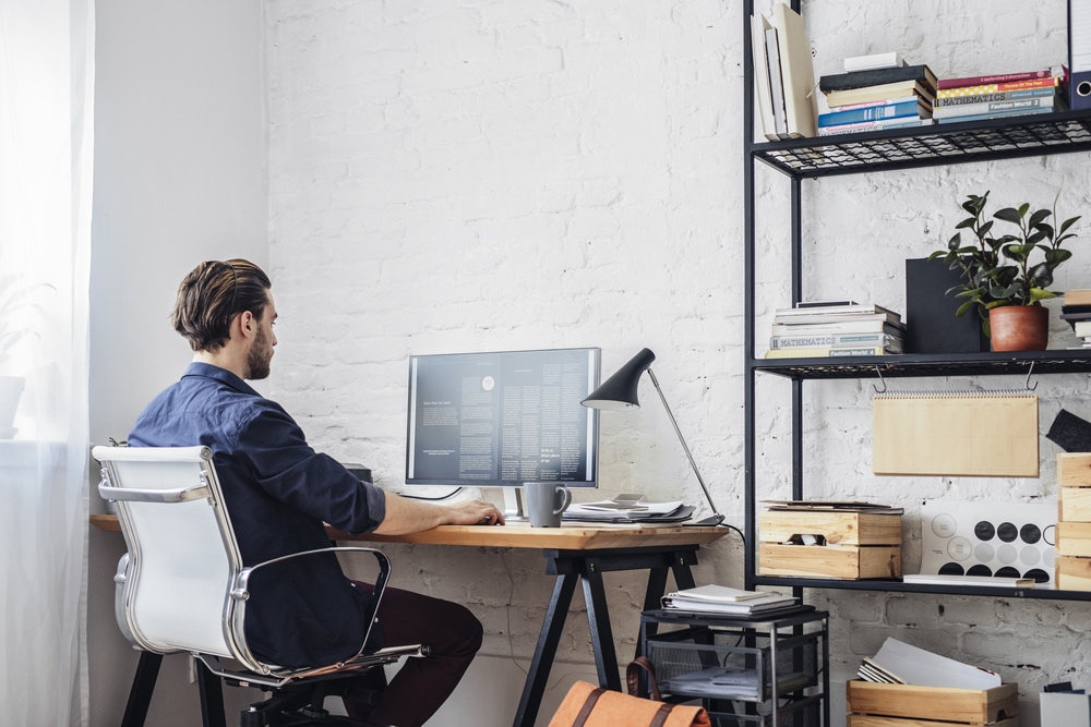 Man sat at desk working from home using team collaboration software