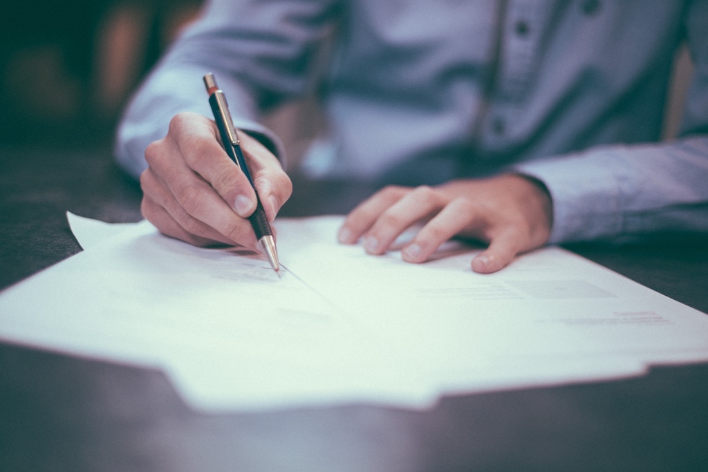 Man writing out a work-from-home proposal for his team