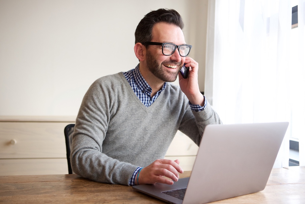 Man laughing while overcoming tyechology problems working from home