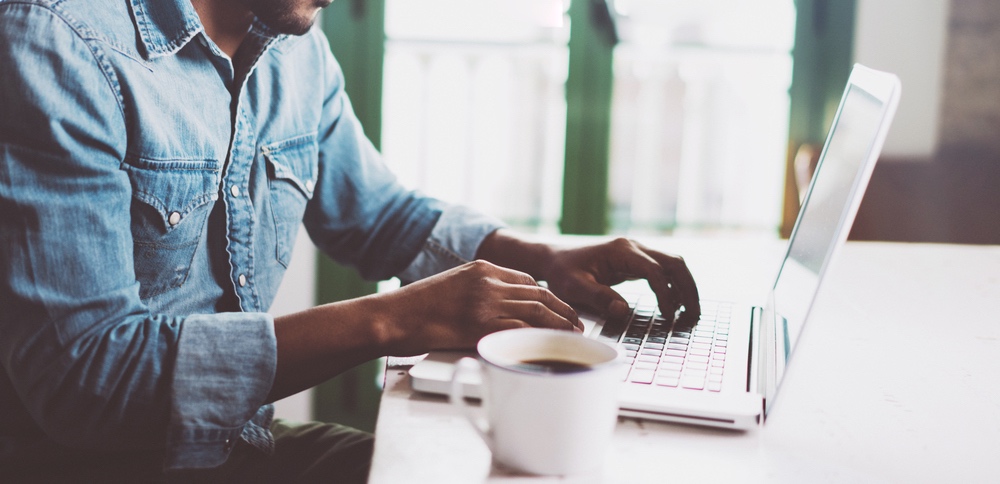 Man in denim shirt collaborating with his team while working from home