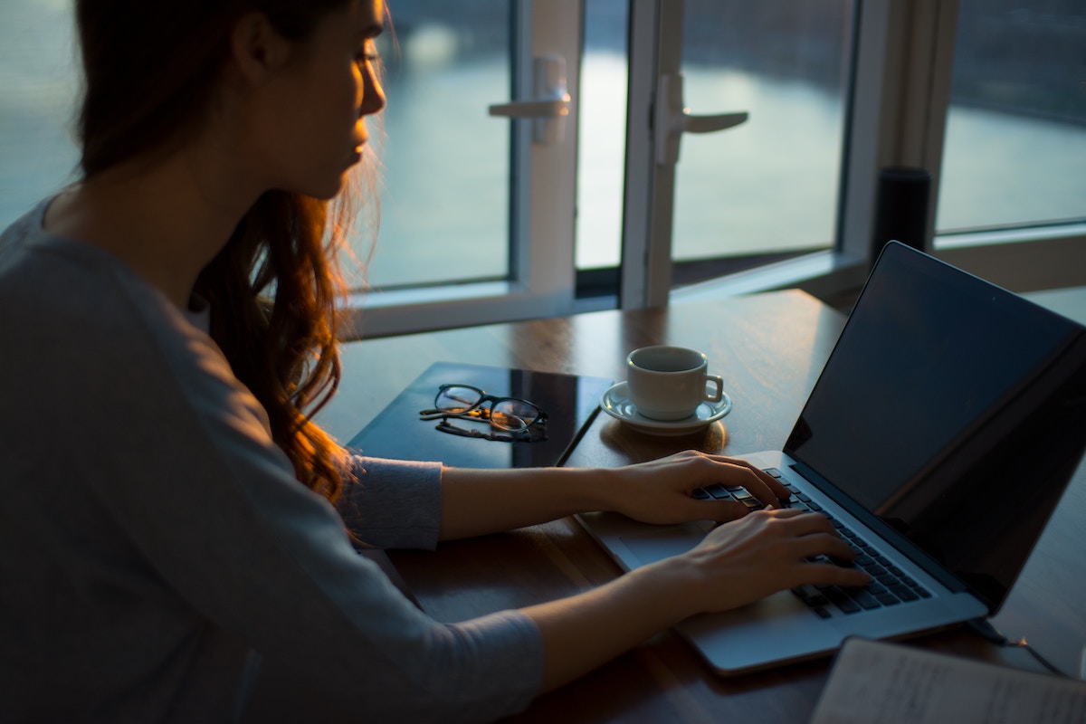 Woman sat at laptop communicating with her team from Anywhere