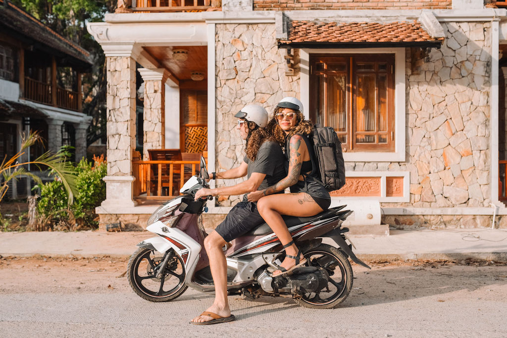 Travellers on motorbike in SE Asia with Tortuga backpacks
