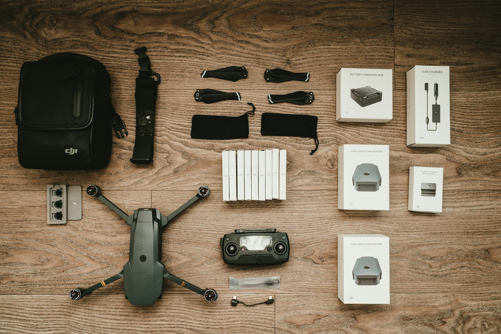 drone with batteries, controller, and accessories arranged on a wooden desk