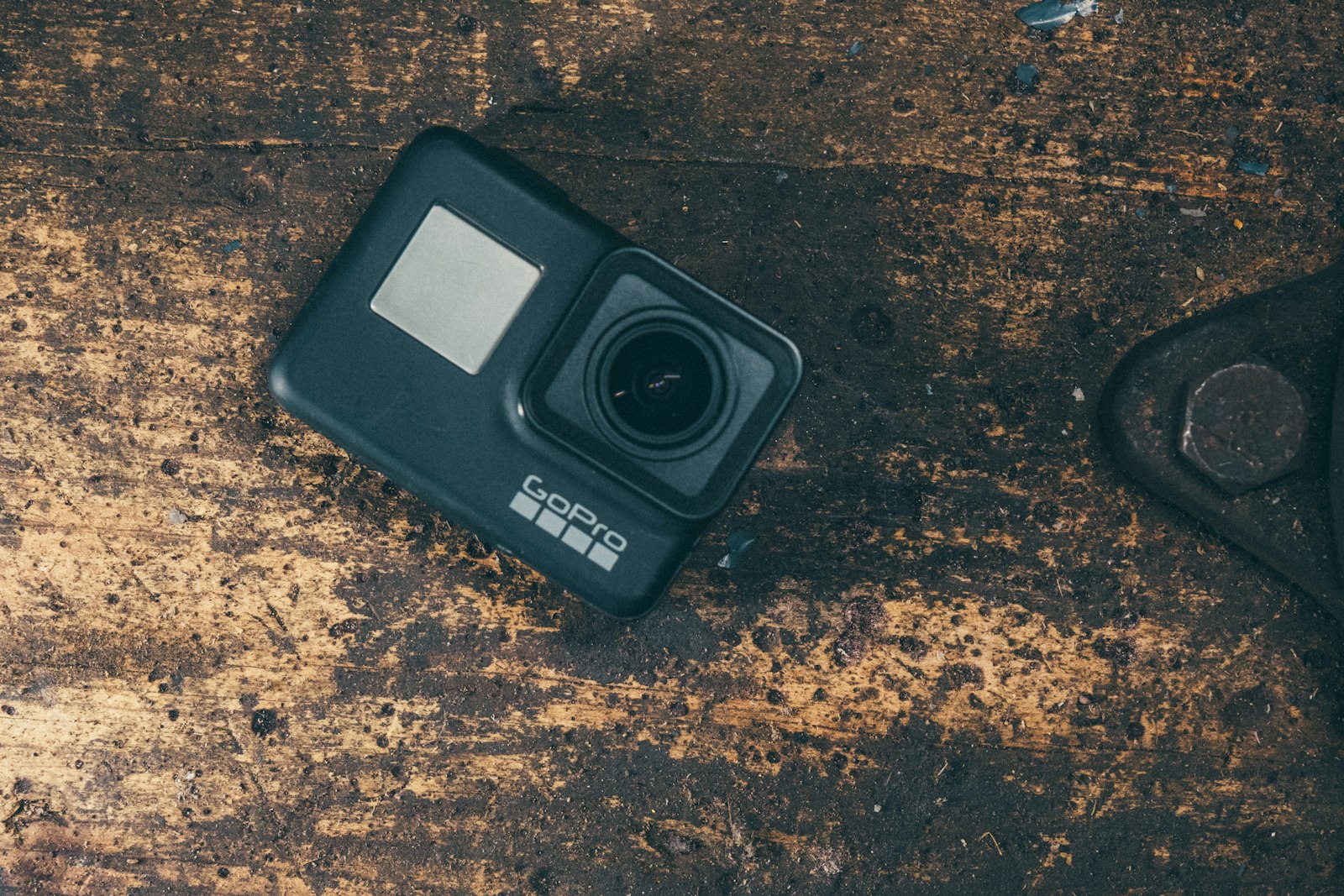 black action camera lying on a weathered wooden table