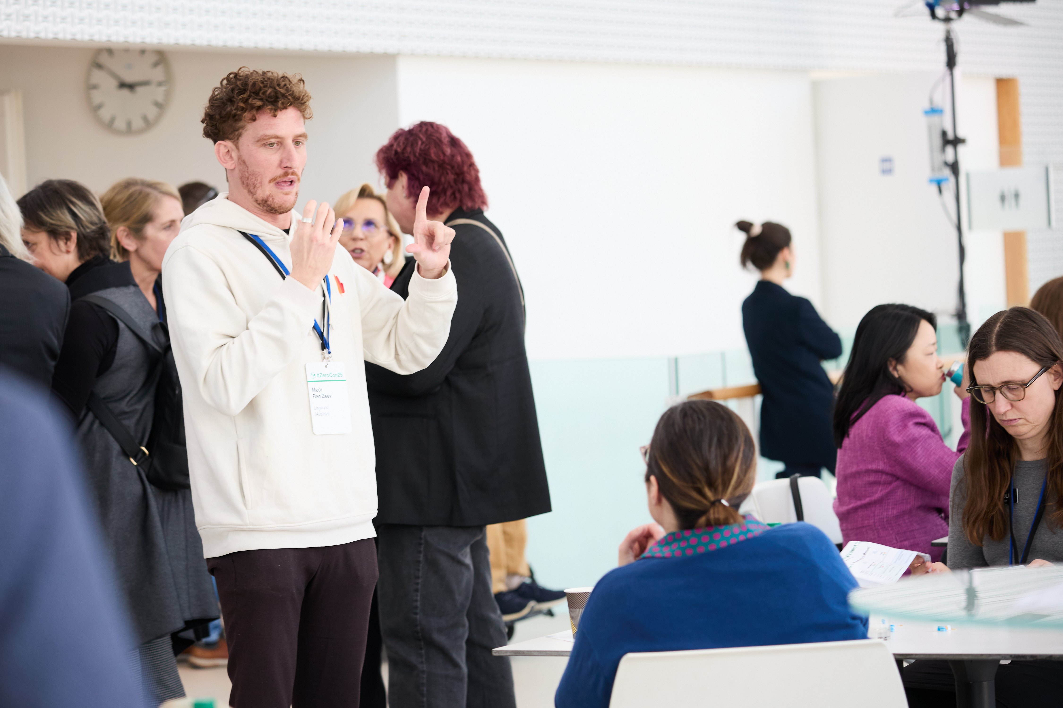A photo of  a conversation between a conference participant, who is signing, and another person.