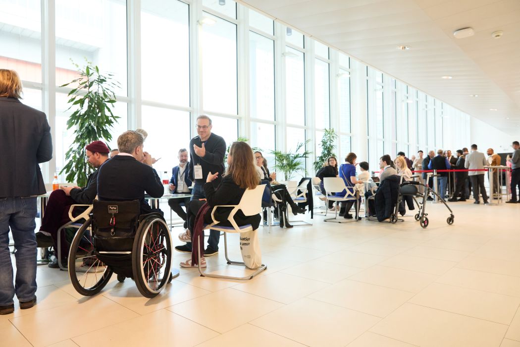A photo showing people seated at or standing next to coffee tables inside the M-Building