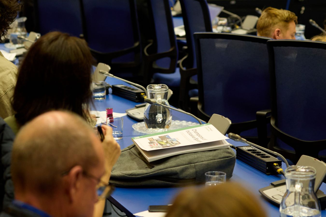 Close-up of a table in the plenary room, showing a power outlet unit with multiple sockets.
