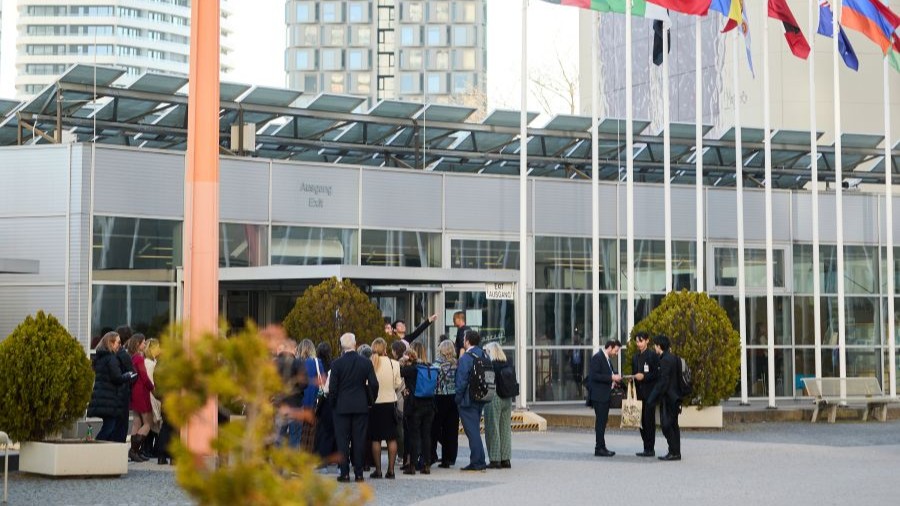 A group of people is seen outside the visitors entrance of the VIC