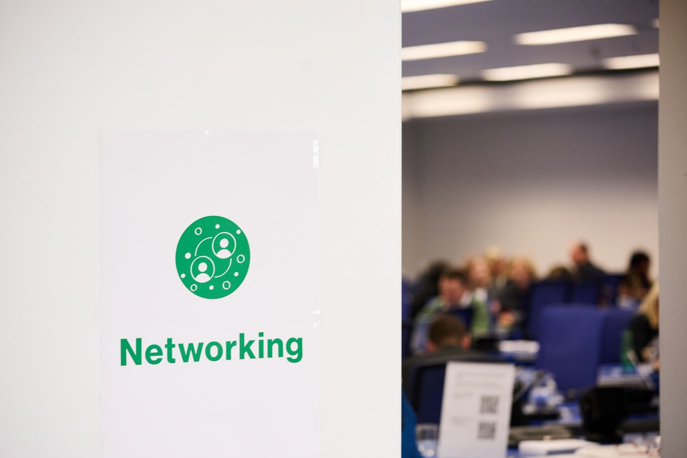 The networking area seen through a half-open door; on the door, there is a poster reading "networking"