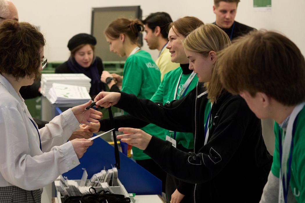 Volunteers handing over name badges during registration