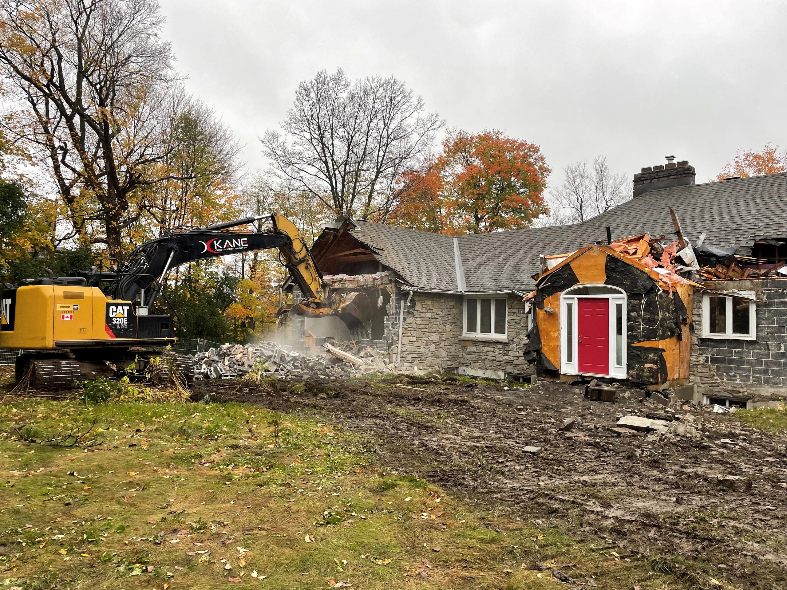 Excavator demolishing house