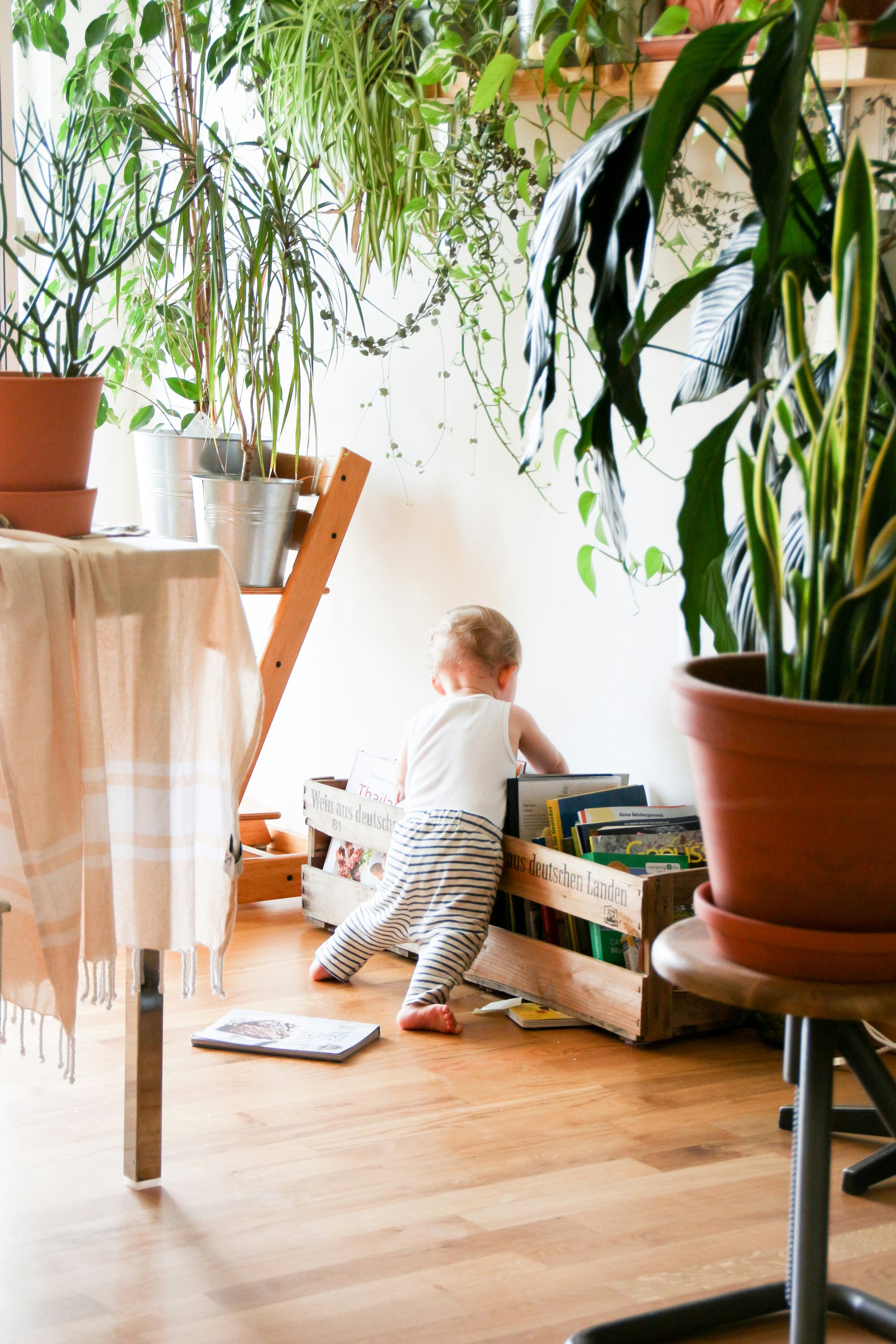 Baby making a mess of books on living room floor