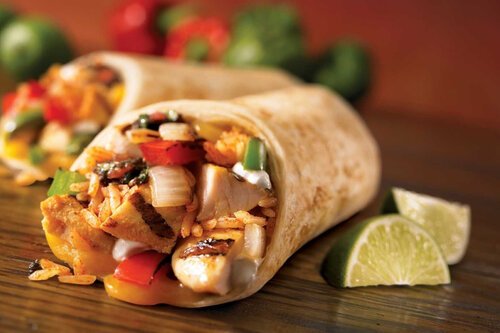 Holistic nutrition thumbnail - two rice and chicken fajitas sit on a wooden table, peppers in background