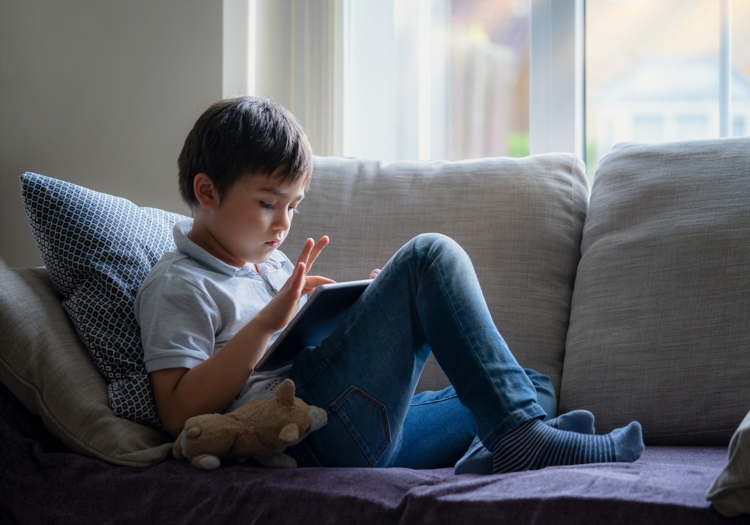 Child reading a tablet at the library