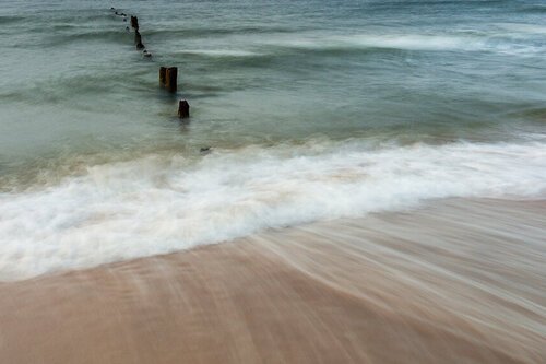 Counselling thumbnail - a sandy beach with waves and part of a fence recede into the water